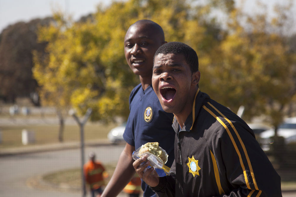 Two enthusiastic spectators cheering loudly at firefighter competition showing team support and energy