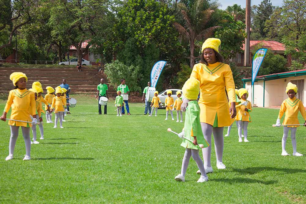 Young drum majorettes in yellow and green uniforms performing at the Nappy Run in Pretoria