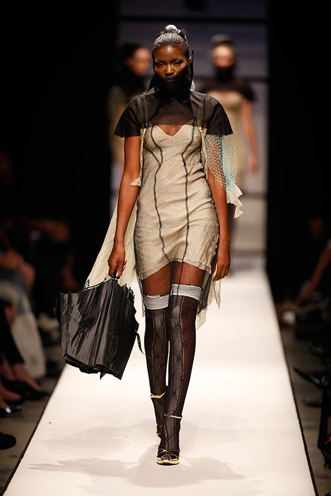 Model wearing contemporary structured dress with deconstructed design on SA Fashion Week runway Johannesburg