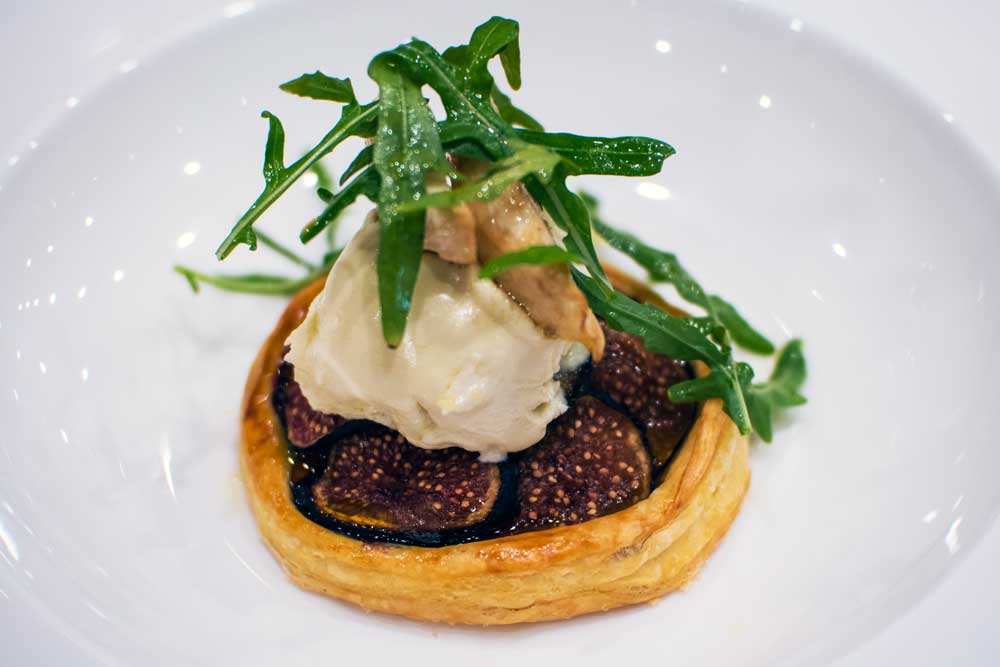 Gourmet fig tart with cheese and rocket on puff pastry, professional restaurant photography