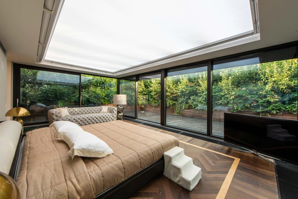 Premium hotel suite with glass walls and garden views at luxury accommodation in Sandton