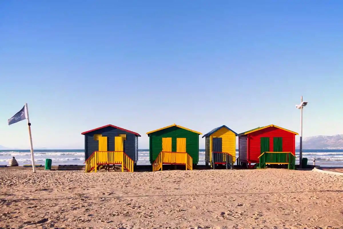 Iconic colourful beach huts at Muizenberg Beach under a blue sky, Cape Town